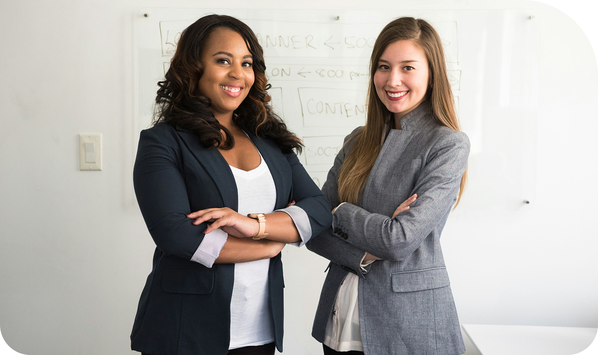 Two business professionals standing together with crossed arms in a modern office, representing teamwork, collaboration, and leadership.